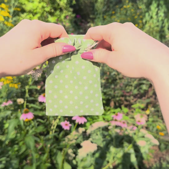 Green polka dot bag opens to reveal silver and gold Claira bracelet with magnetic clasp