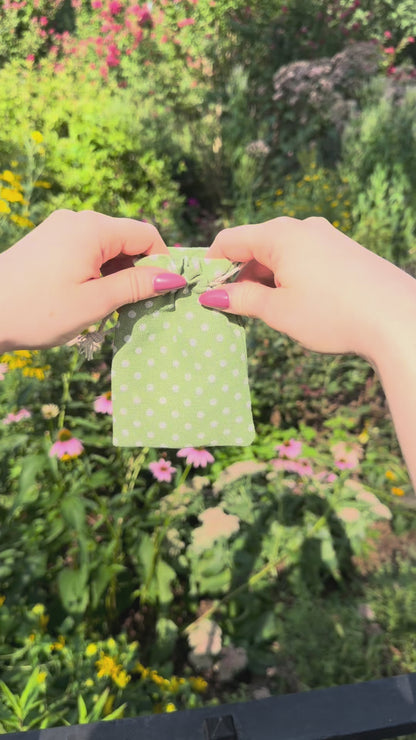 Green polka dot bag opens to reveal silver and gold Claira bracelet with magnetic clasp