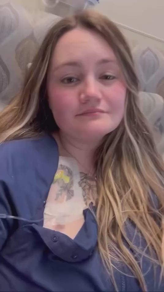 Woman with a chest port showing how the hospital gowns chest snaps can be used to access her port.